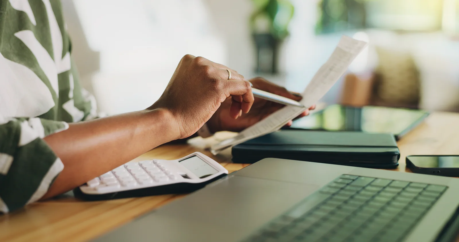 Business owner holding a paper receipt at a desk before scanning it into Byna
