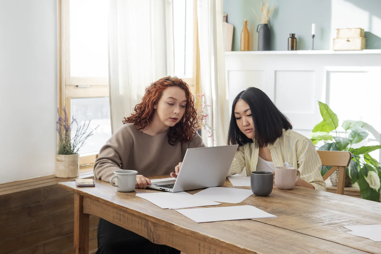 Two colleagues going through the week together behind one laptop in a small office